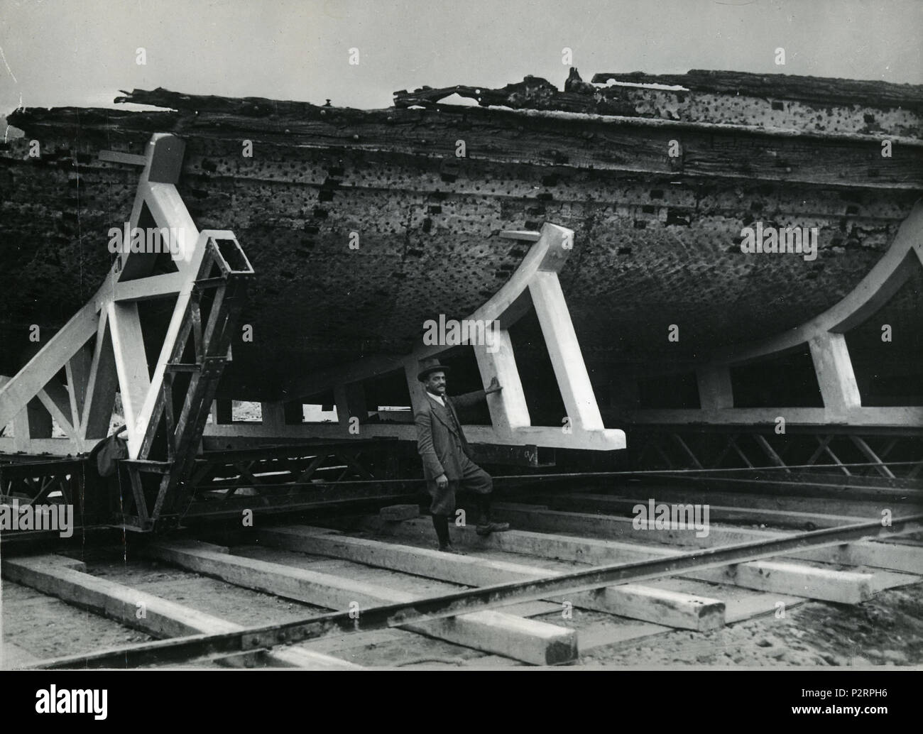 . Italiano: Navi di Nemi. La prima nave posizionata sull'invasatura, sorretta da onu carrello in ferro, scorrente su rotaie. Una persona non identificata posa appoggiata all'invasatura. 1928. Anonimo 4 Alaggio prima nave di Nemi - Museo scienza e tecnologia Milano come 00206 Foto Stock