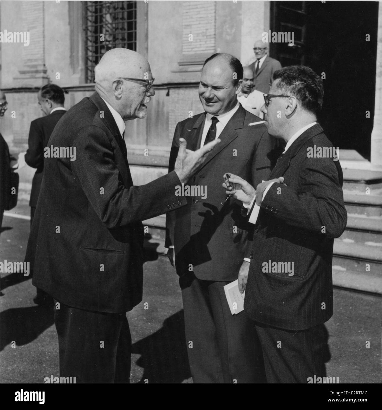 . Inglese: una foto a prendere al Simposio Internazionale sulla geometria algebrica, svoltosi a Roma dal il primo piano da sinistra a destra: Enrico Bompiani parlando con Giovanni Battista Rizza e Vittorio dalla volta. Sullo sfondo da sinistra a destra: Beniamino Segre (solo parte della sua figura e faccia è visibile) parlando con Enzo Martinelli, mentre Giovanni Ricci (nei pressi del palazzo porte) è andare al piano di sotto. Alcuni giorni tra il 30 settembre e il 6 ottobre 1965. Deutsch: Fotographie vom Internationalen Symposium über Algebraische geometria nella ROM 1965. Im Vordergrund, von links Foto Stock