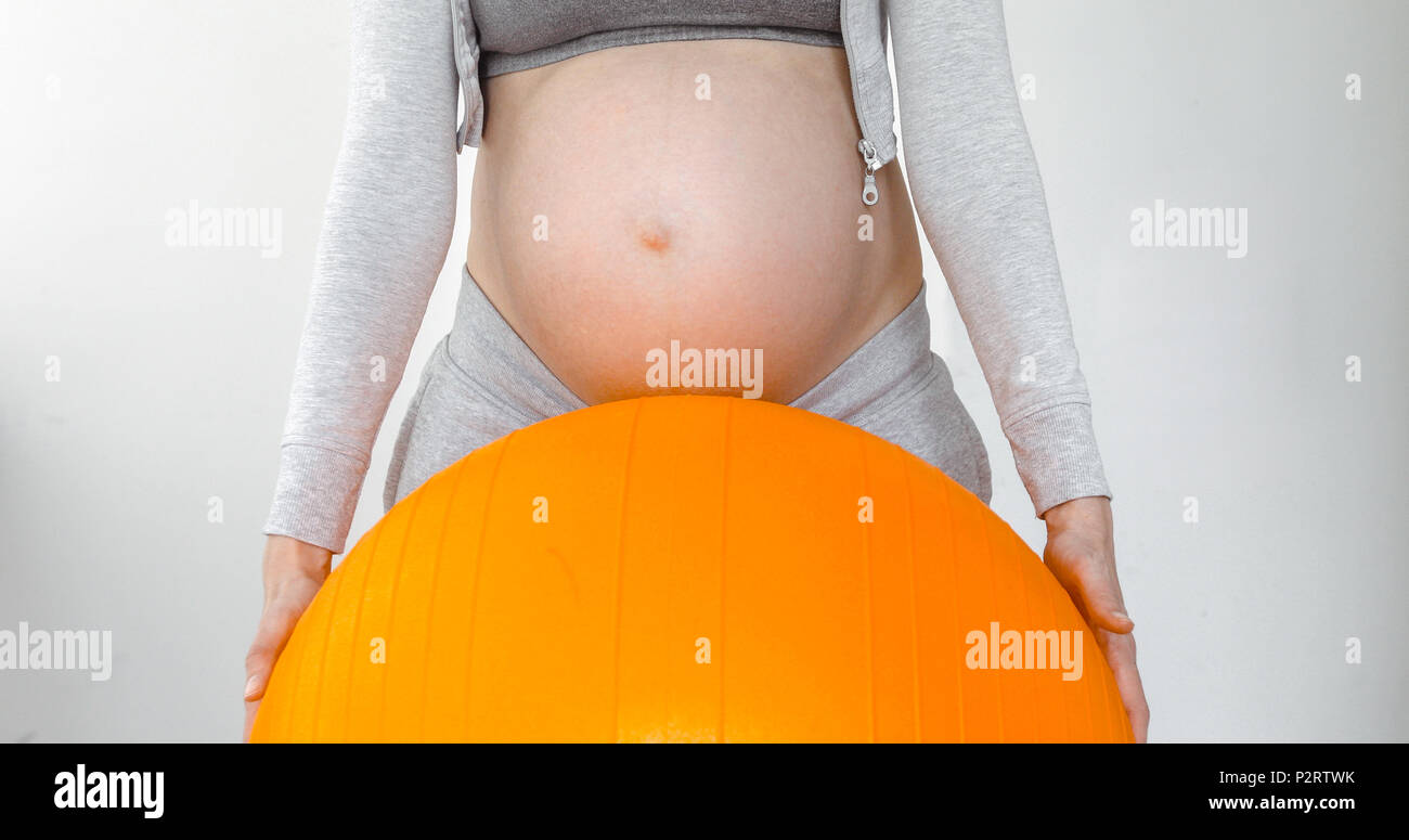 Donna incinta in possesso di una sfera di fitness Foto Stock