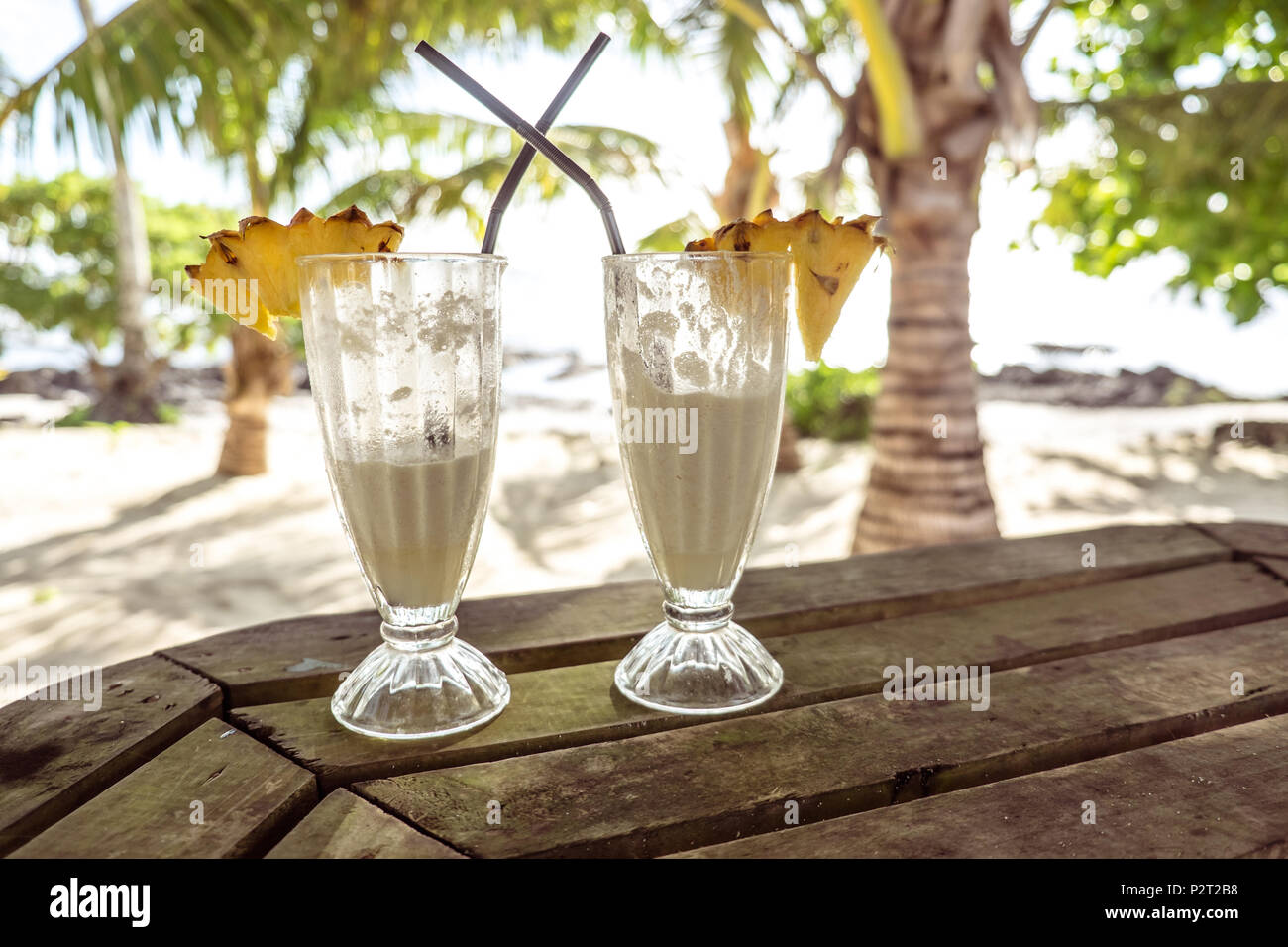 Mezzo pieno di bicchieri di tropical pina colada cocktail drink con ananas  decorazione in vetro con cannucce a esotica spiaggia a Lefaga, Isola Upolu,  Western Foto stock - Alamy