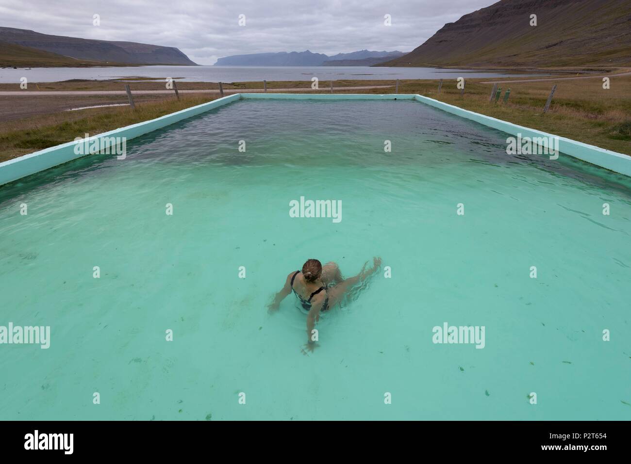 L'Islanda, a ovest di fiordi, Bildudalur, Reykjarfjordur, donna in una piscina geotermica al fondo del fiordo di Arnarfjörður Foto Stock