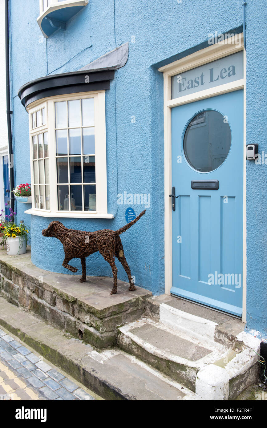 Cane di vimini al di fuori di un edificio sulla Strada Alta nel villaggio di Staithes, North Yorkshire England Regno Unito Foto Stock