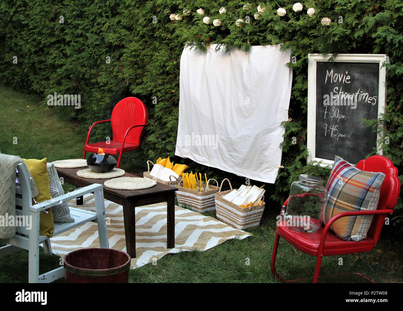 Foglio bianco pronto per un film la notte all'aperto con cibo e sedie Foto Stock