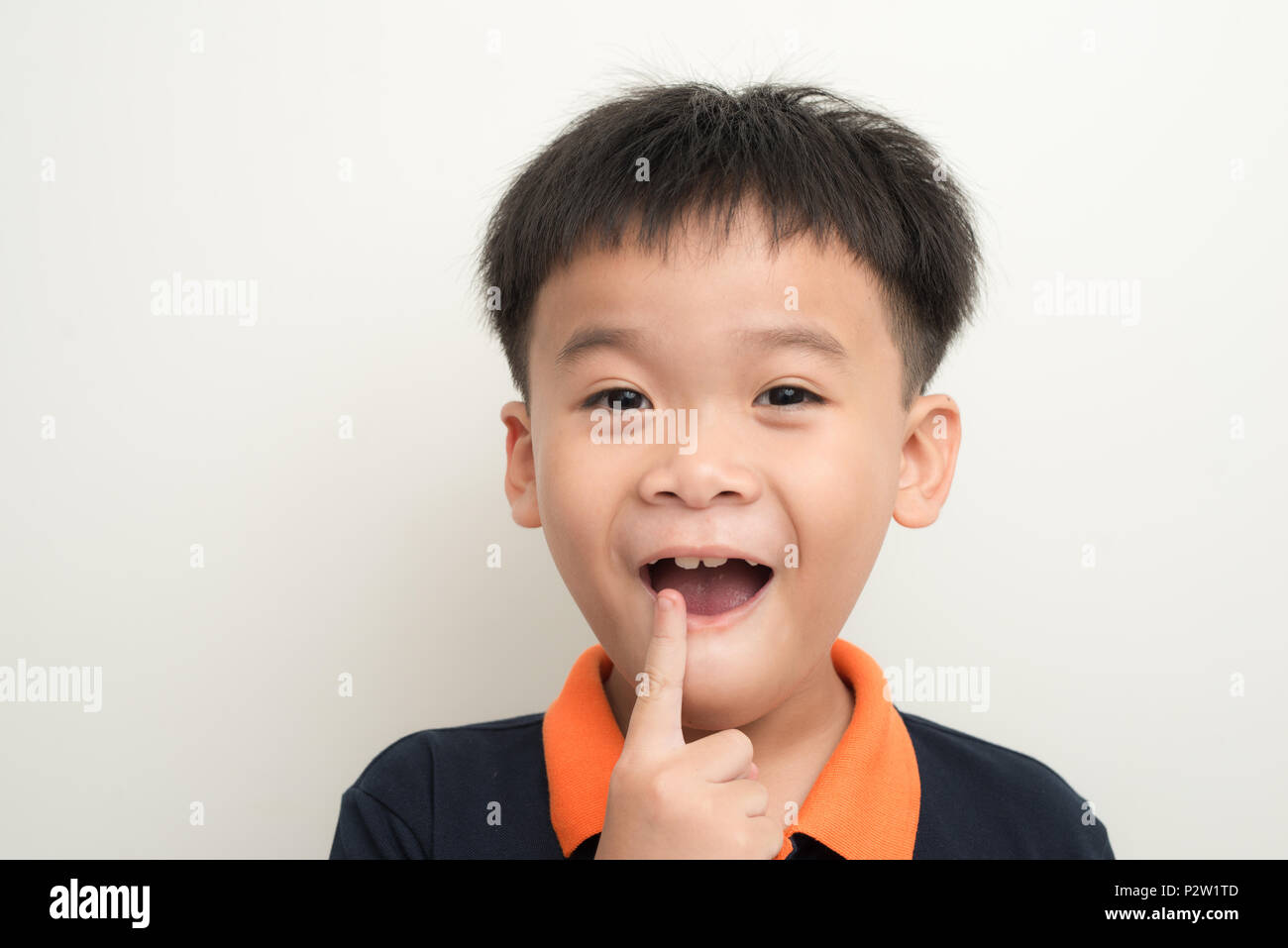Priva di denti ragazzo sorridente che mostra il suo dente perduto il latte Foto Stock