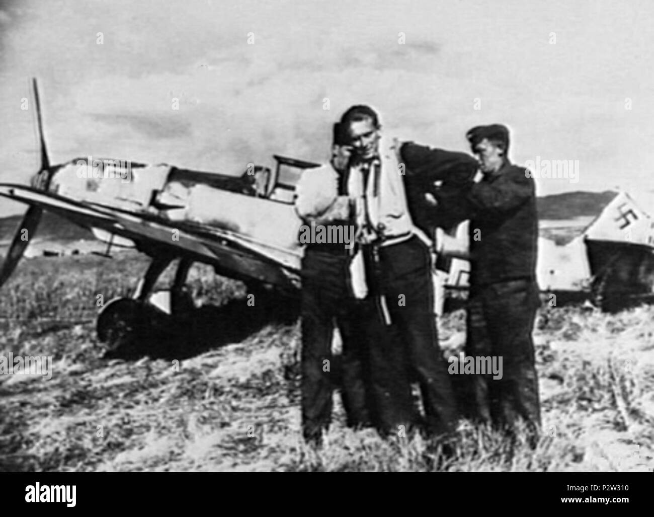 . Tedesco Luftwaffe pilot Erbo Graf von Kageneck, titolare del cavaliere del Cross della croce di ferro con foglie di quercia, in piedi davanti al suo Messerschmitt Me 109E in Sicilia, l'Italia, pur essendo assistito da due equipaggio a terra del personale. Von Kageneck, responsabile per la distruzione di 69 aerei alleati, più successivamente è stato abbattuto da RAAF, pilota ufficiale di volo Clive R. Caldwell, (che è stato fissato a 250 Squadrone, Royal Air Force) nel pomeriggio del 24 dicembre 1941 nei pressi di Derna in Libia. Kageneck più tardi morì in volo per un ospedale a Napoli il 12 gennaio 1942. 1941. 26 sconosciuto Erbo Graf von Kageneck con Foto Stock