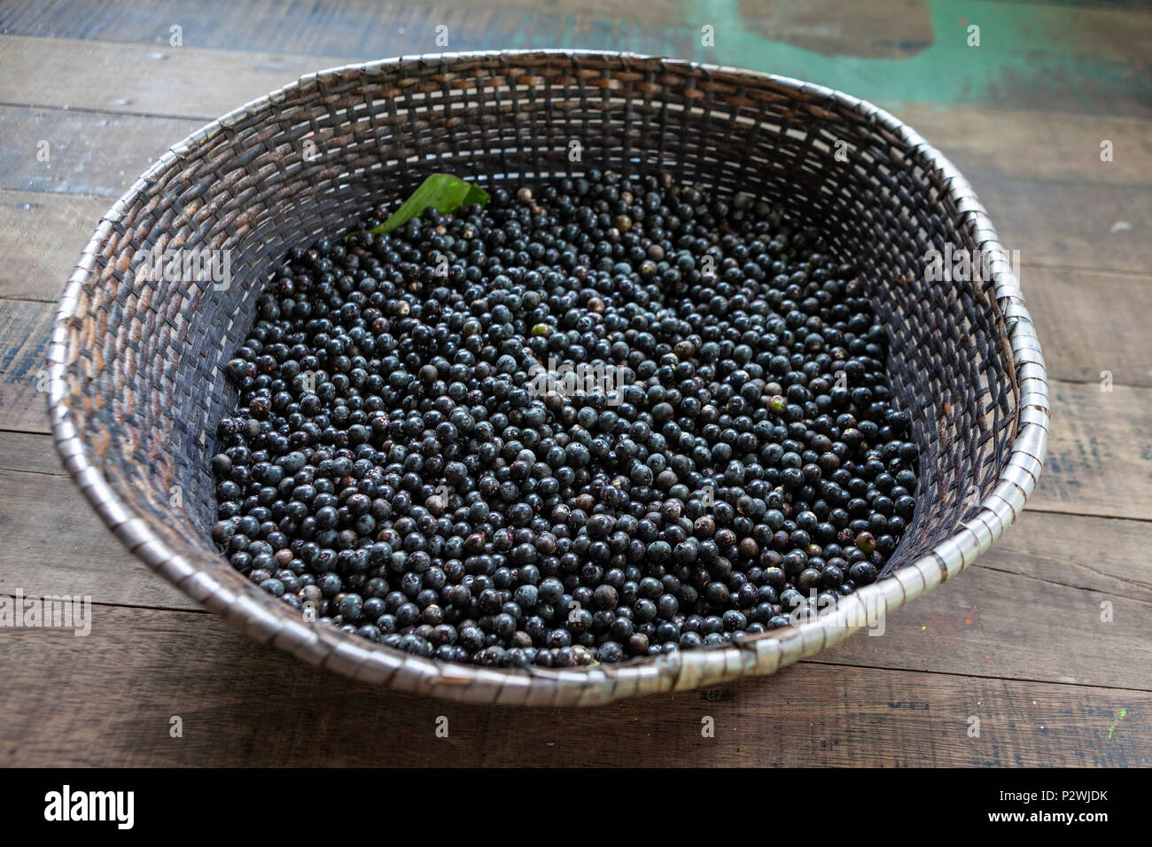 La paglia cesto pieno di prodotti freschi acai bacche di vendere a un equo nella città di Belem, Brasile. Foto Stock