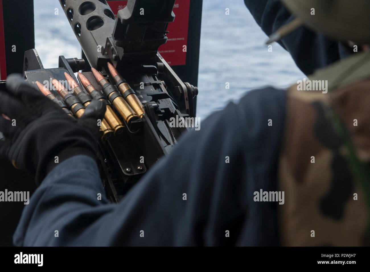 Ordnanceman Airman Paige Henning, da Phoenix, carichi di un M2HB .calibro 50 mitragliatrice sul fiocco della Nimitz-class portaerei USS Carl Vinson (CVN 70). Carl Vinson e la sua aria imbarcato ala, Carrier aria Wing (CVW) 17, sono sulla distribuzione nel 7 ° Flotta area di operazioni il supporto di sicurezza e stabilità nella Indo-Asia-regione del Pacifico. ( Foto Stock