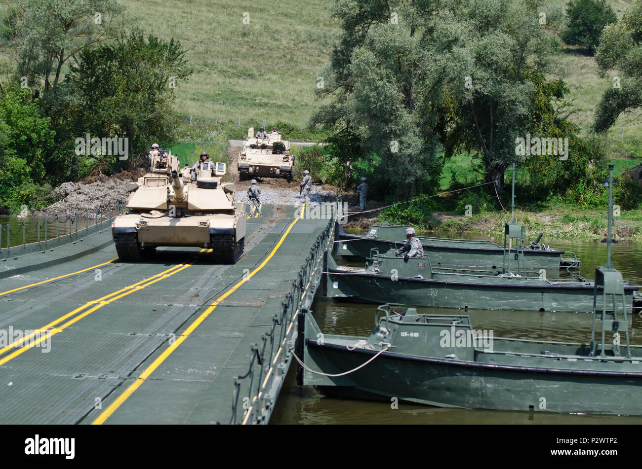 Soldati con la 116Brigata di cavalleria contro la squadra, Idaho National Guard, guidare le loro M1A2 Abrams serbatoio attraverso un nastro migliorate bridge istituito dal 125th Multi Role Bridge Company, Carolina del Sud la Guardia Nazionale, sul fiume Olt vicino Voila, Romania, 1 Agosto durante un esercizio di Saber del tutore 16. Saber Guardian 16 è una multinazionale di esercitazione militare che coinvolge circa 2.800 militari provenienti da dieci nazioni tra cui l'Armenia, Azerbaigian, Bulgaria, Canada, Georgia, Moldavia, Polonia, Romania, Ucraina e Stati Uniti Gli obiettivi di questo esercizio sono la costruzione di multinazionale, regionale e joi Foto Stock