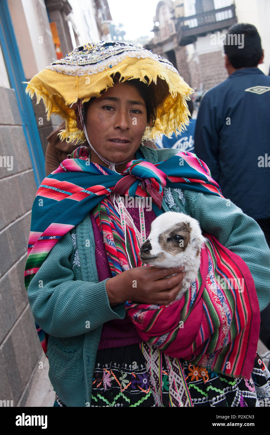 Donna Peruviana in costume tradizionale mentre tiene il suo agnello in Cusco Peru Sud America Foto Stock