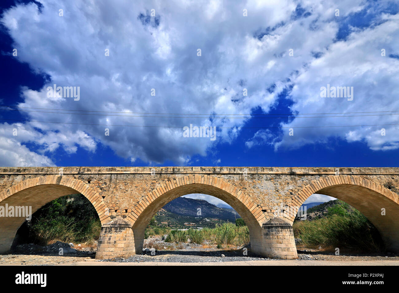 Antica pietra ponte arcuato (costruito nel 1884) vicino al villaggio di Myrtos, Ierapetra comune, Creta, Grecia. Foto Stock