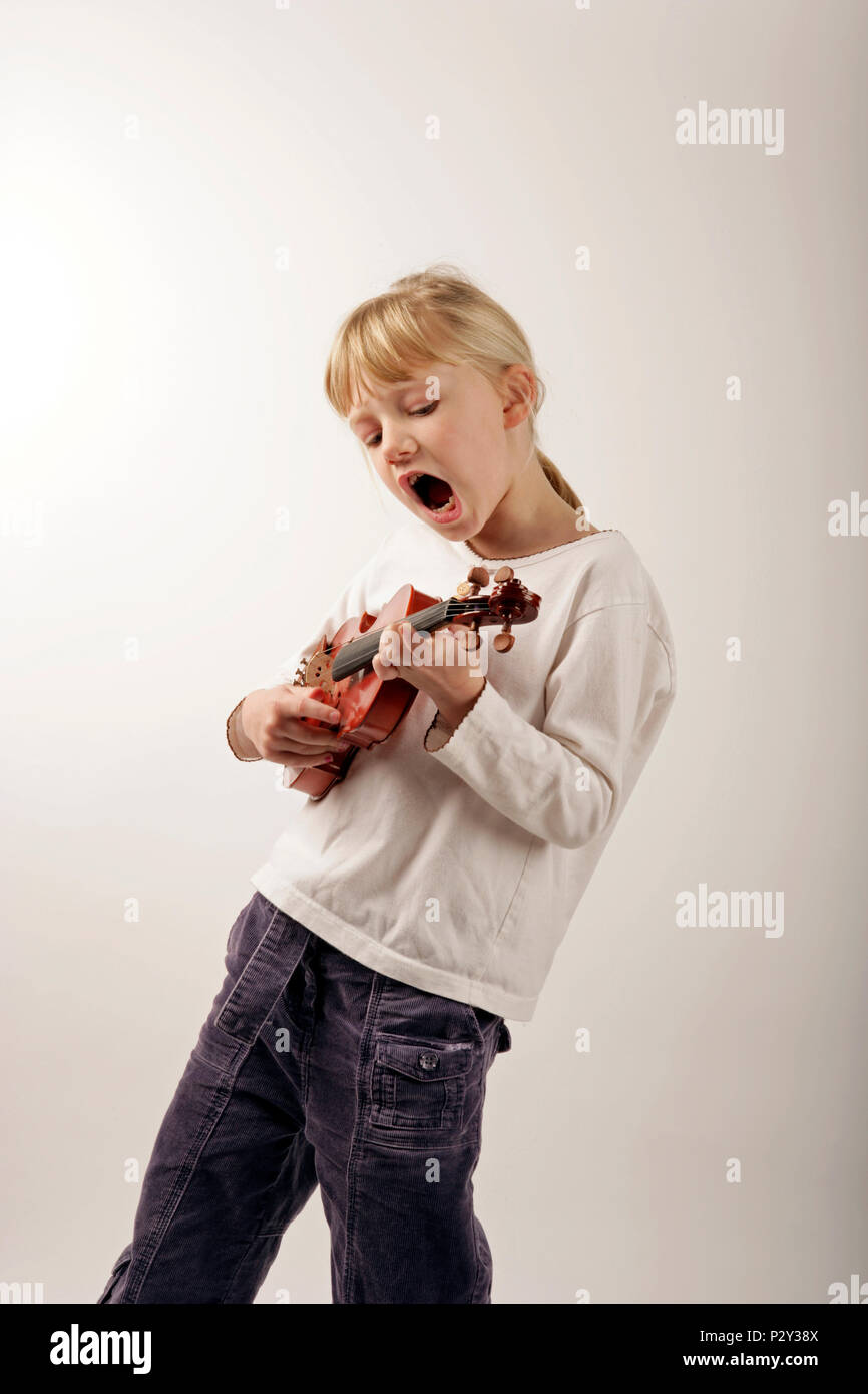 Ragazza giovane con un violino, spiumatura e canto Foto Stock