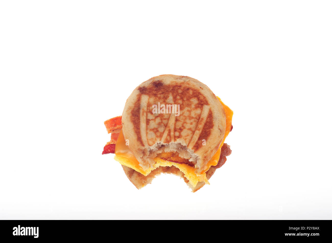 McDonald's McGriddle pancetta, uova e formaggio prima colazione veloce sandwich di alimentare con il morso preso isolato su bianco Foto Stock