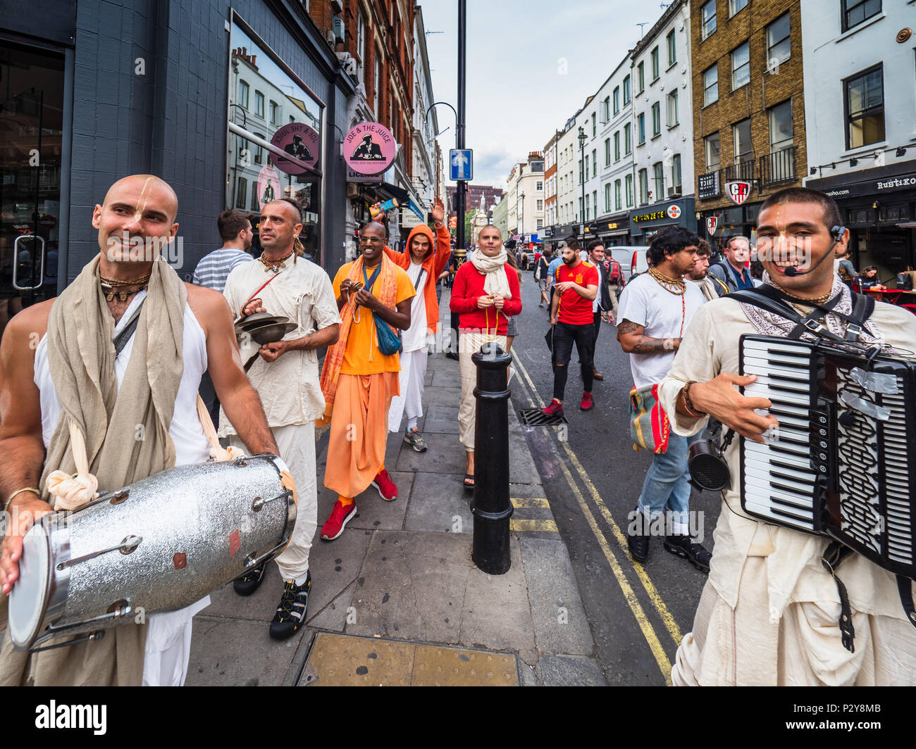 Hare Krishna Chanters muoversi attraverso Old Compton Street a Londra nel quartiere di Soho di consegnare gli inviti per il cibo gratis a Radha Krishna Temple. Foto Stock