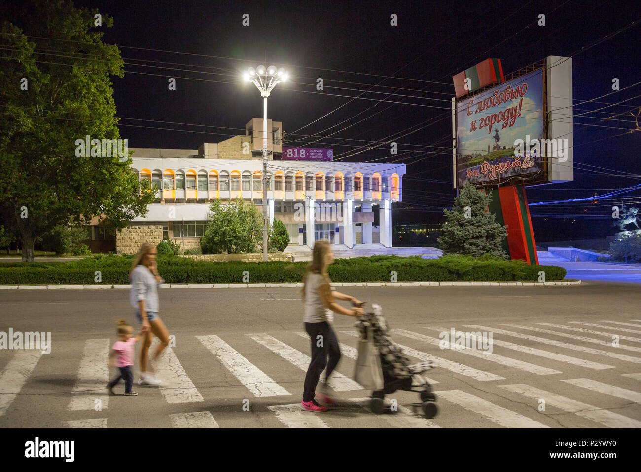 25.08.2016, Tiraspol, Transnistria Moldavia - i passanti, illuminato dalla propaganda politica e ex Pioneer Palace (ora: Palazzo dei bambini e Foto Stock