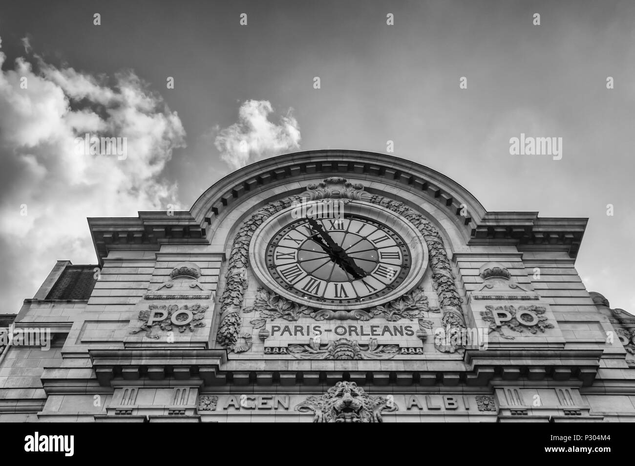 Un buio, drammatico, immagine dell'orologio sulla sommità del Musée d'Orsay a Parigi. In precedenza la Gare d'Orsay stazione ferroviaria con treni che circolano tra Parigi di Orleans, è oggi un museo. Impostare contro un cielo nuvoloso con copia spazio. Foto Stock