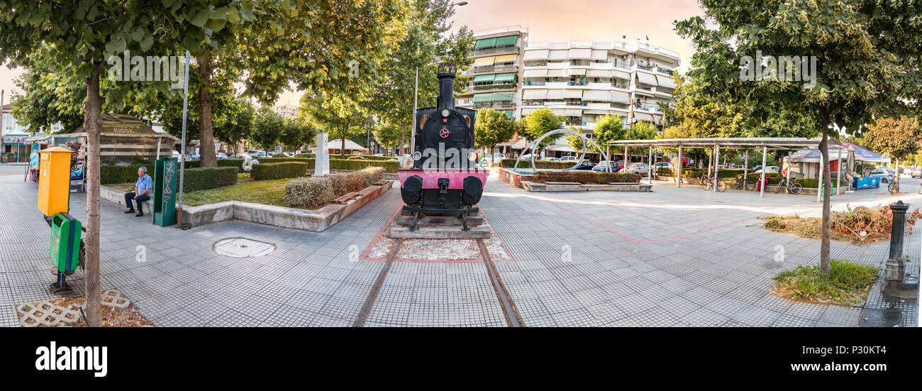Larissa, Grecia - Giugno 11th, 2018: Panorama della Platia ose con una vecchia locomotiva realizzato dall'azienda Krupp accanto a Larissa stazione ferroviaria. Foto Stock