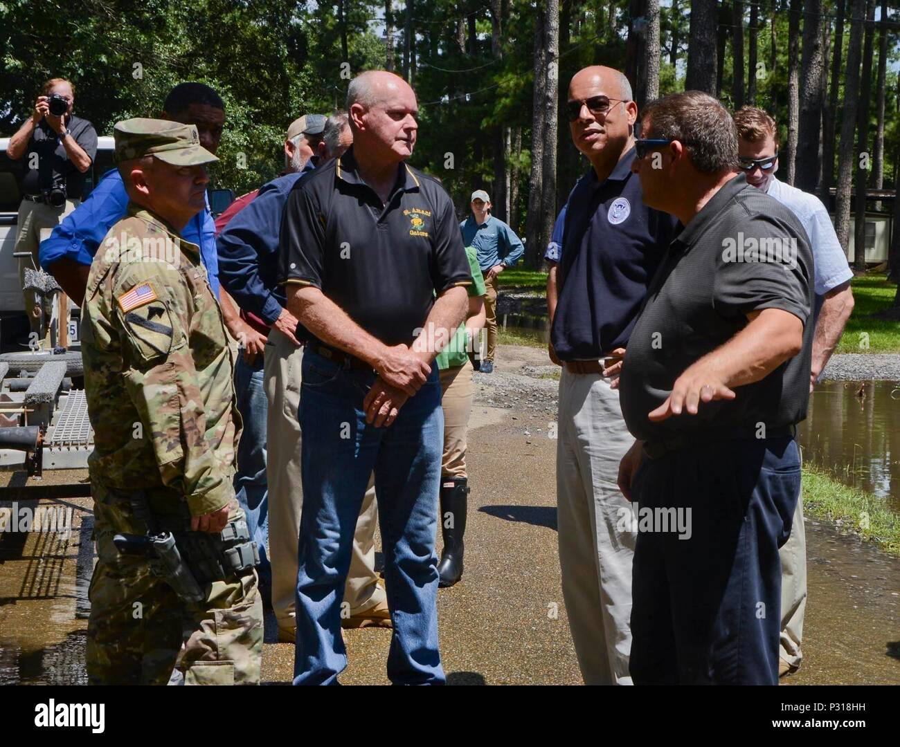 Stati Uniti Esercito Lt. Col. Cameron Magee, comandante della 2° Stormo, 108th reggimento di cavalleria, Louisiana esercito Guardia nazionale, a sinistra e a James Leblanc, fire chief di San amante volontario del reparto antincendio, centro, spiegare e mostrare Jeh Johnson, Segretario del Dipartimento per la sicurezza interna, il flood i risultati di risposta sui quartieri di San amante, La., Agosto 18, 2016. Guardie Nazionali sono stati attivati per assistere gli enti locali e le autorità statali a seguito di registrare le inondazioni che hanno colpito la Louisiana, Texas e Arkansas nel 2016. (U.S. Esercito nazionale Guard foto di Sgt. Noshoba Davis) Foto Stock