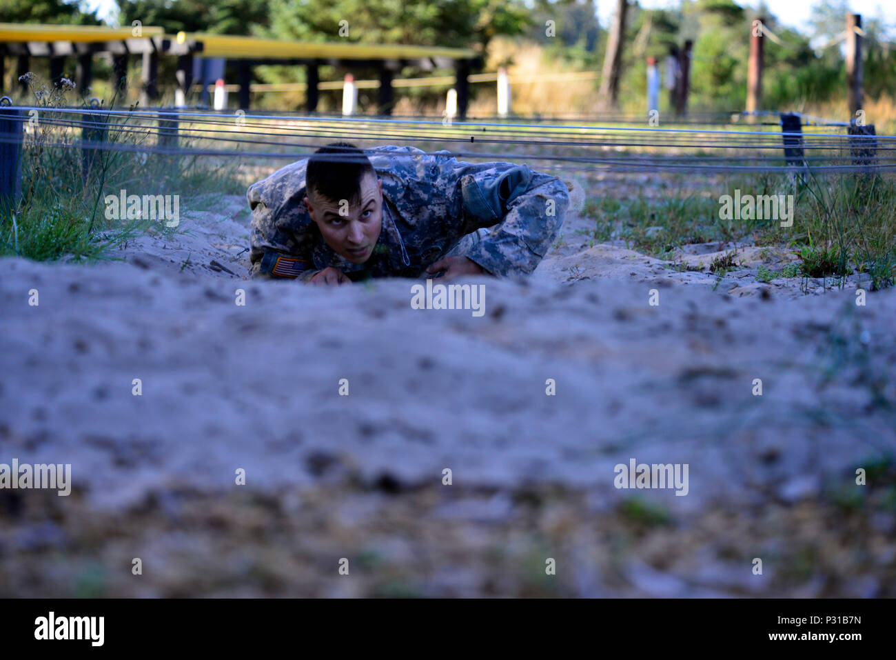 Un esercito di Oregon nazionale soldato di guardia alta-crawl attraverso una porzione del percorso ad ostacoli a Camp Rilea, 19 agosto nel corso dell'Oregon guerriero migliore concorrenza in Warrenton, Oregon. I soldati hanno gareggiato a guadagnarsi un posto come il soldato o Sottufficiale (NCO) dell'anno e continuare su rappresentano Oregon in Northwest Regional miglior guerriero della competizione in programma per il maggio 2017. (Foto di Capt. Leslie Reed, XLI della brigata di fanteria combattere la squadra degli affari pubblici) Foto Stock