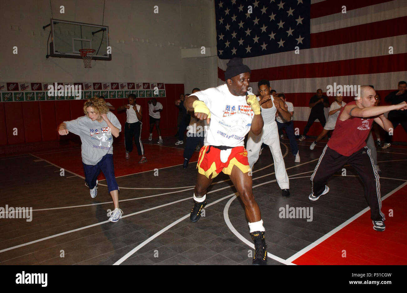 Italia, 11 genn. 2002 --. Segnalatore marinaio Jeremy Cavaretta di New York (destra) funziona con Billy fustellati (al centro), il creatore di "Tae bo', durante la sua visita a bordo della sesta flotta ammiraglia USS La Salle (AGS 3). Gli sbozzati era a bordo per un nastro-cerimonia del taglio di aprire ufficialmente una nuova pista polivalente a bordo. Il $29.000 facility, che è stata finanziata completamente da non appropriati o non-i fondi del contribuente, è parte di un continuo sforzo di migliorare esercitare strutture per marinai che prestano servizio in mare. Foto Stock