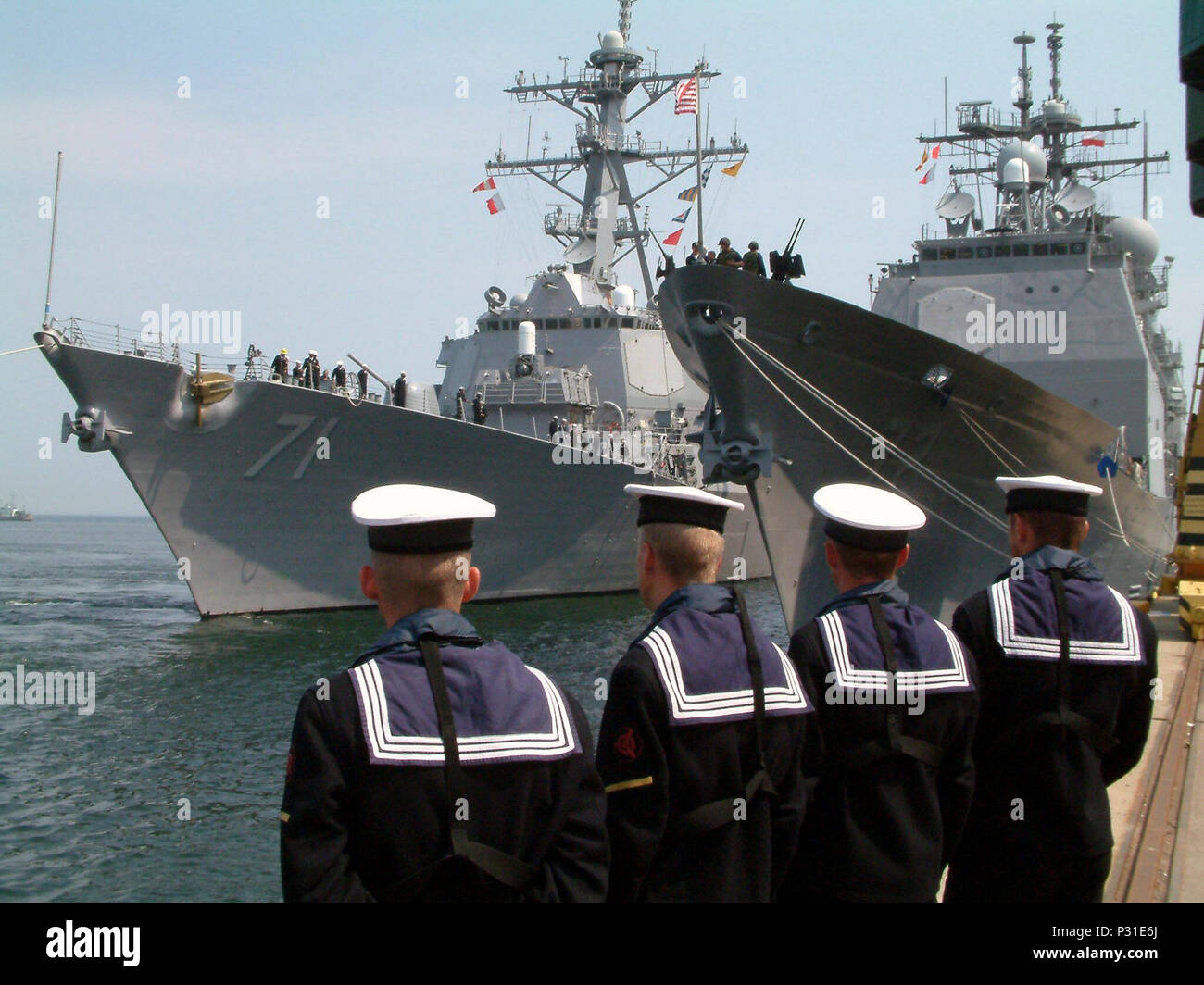 Porto, Polonia (Jun. 05, 2003) -- marinai polacco guarda come il missile destroyer USS Ross (DDG 71) trascina lungo il lato del missile cruiser USS Vella Gulf (CG 72) prima dell'inizio Baltops 2003. Gli Stati Uniti e altri 11 nazioni partecipano a questo anno di esercizio. BALTOPS 2003 è destinato a migliorare l'interoperabilità tra gli alleati e il Partenariato per la pace paesi mediante la conduzione di un supporto di pace operazione in mare comprese le esercitazioni in gunnery, rifornimento in mare, undersea warfare, tracciamento radar, miniera di contromisure, marinaio, operazioni di ricerca e salvataggio, marittimo interdetto Foto Stock