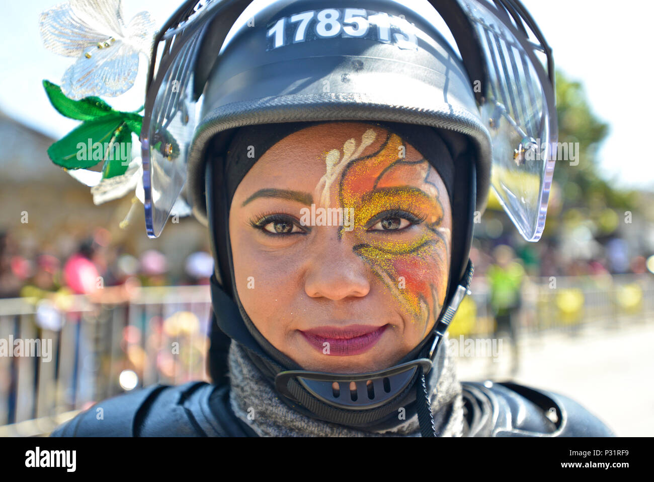 Poliziotta che indossa un casco e una faccia dipinta. Battaglia dei Fiori, Barranquilla Carnaval. Foto Stock