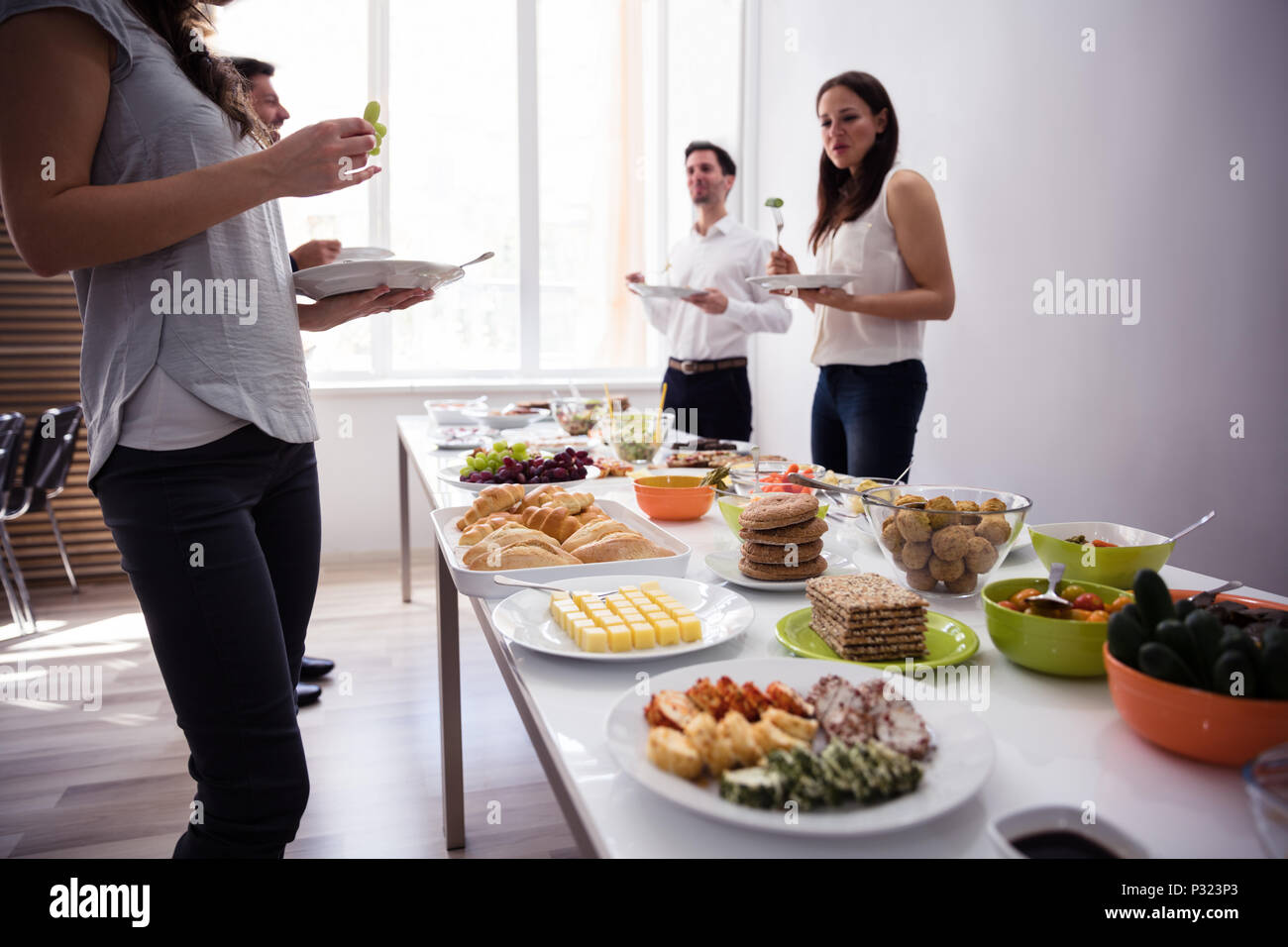 Giovani celebrando con cibo fresco sul tavolo Foto Stock