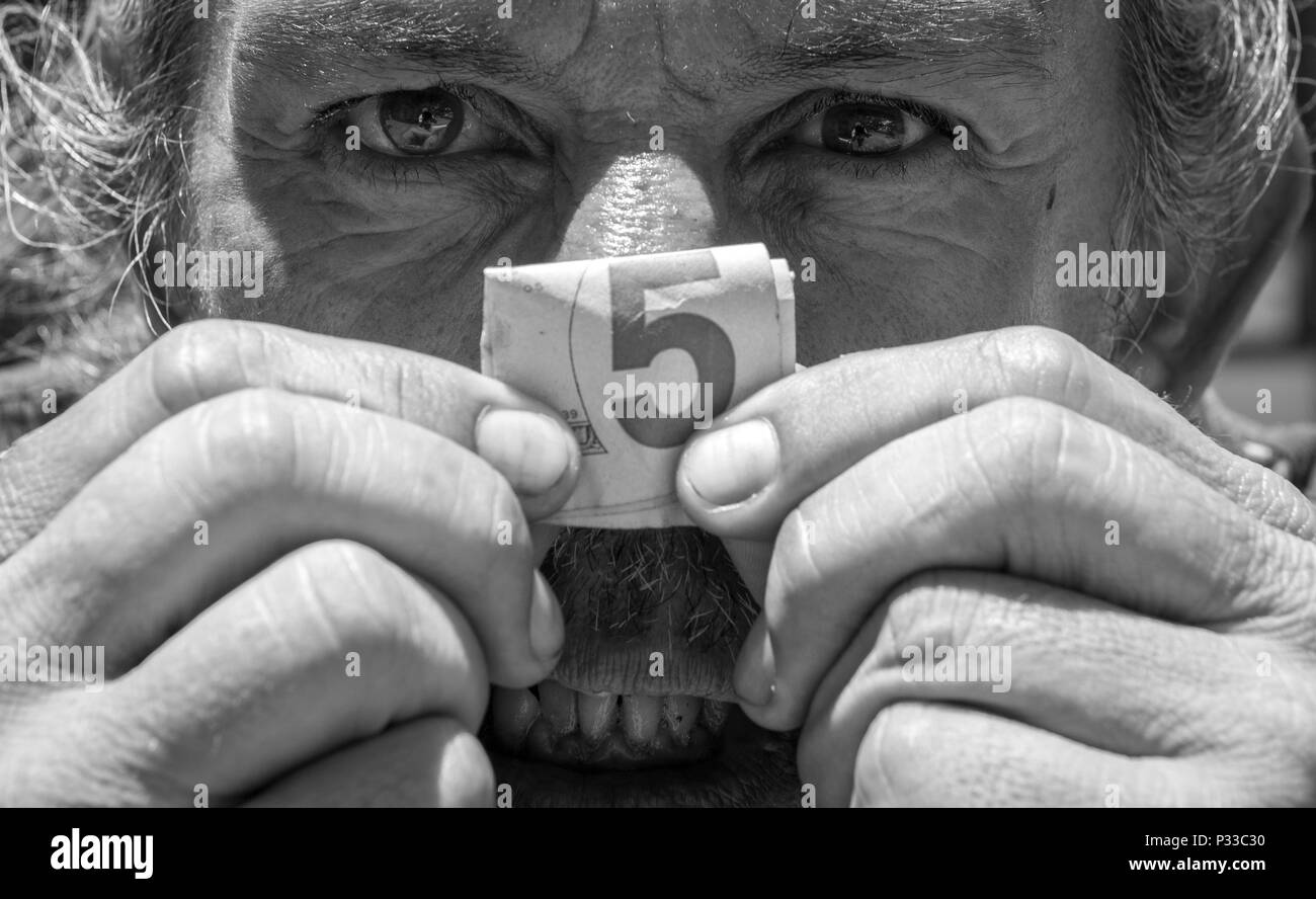 Un senzatetto U.S. Il Veterano dell'esercito mostra un piegato fino a cinque dollari prima di entrare in un negozio nel quartiere di Chinatown di Honolulu, Hawaii, 15 agosto 2016. La scelta di rimanere anonime, egli ha detto che egli ha costantemente rivive la lotta contro le situazioni ha resistito durante il suo tempo in Vietnam. Egli ha anche dichiarato che egli vive in mezzo a decine di altri veterani esperienza anche molti degli stessi sintomi psicologici a causa del loro tempo speso in campo militare. (U.S. Air Force foto di Tech. Sgt. Brandon Shapiro) Foto Stock