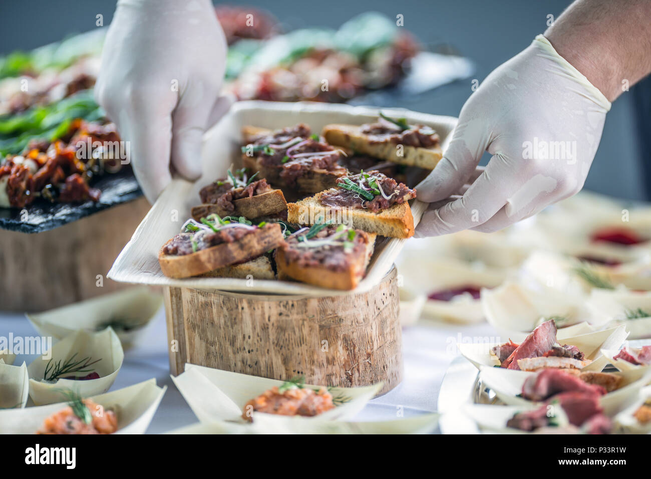 Lo chef prepara materie carni bovine tartaro mini pane su un evento di catering. Foto Stock