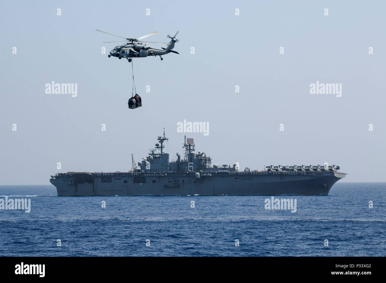 A bordo della USS GREEN BAY (LPD-20), al mare, (Agosto 31, 2016)- Una Marina MH-60S Seahawk dall'USS Bonhomme Richard (LHD-6) offre forniture per un rifornimento in mare sul ponte di volo della USS Green Bay (LPD-20) mentre in corso come parte del Bonhomme Richard Expeditionary Strike gruppo, al mare, 31 Agosto, 2016. Elicotteri da la USS Bonhomme Richard (LHD-6) eseguito forniture dal USNS Charles Drew (T-AKE-10) alle navi del Bonhomme Richard ESG come un prerequisito per la pre-distribuzione nel corso di certificazione integrazione anfibio di formazione tra le navi del trentunesimo MEU e il BHR ESG. (U.S. Mar Foto Stock