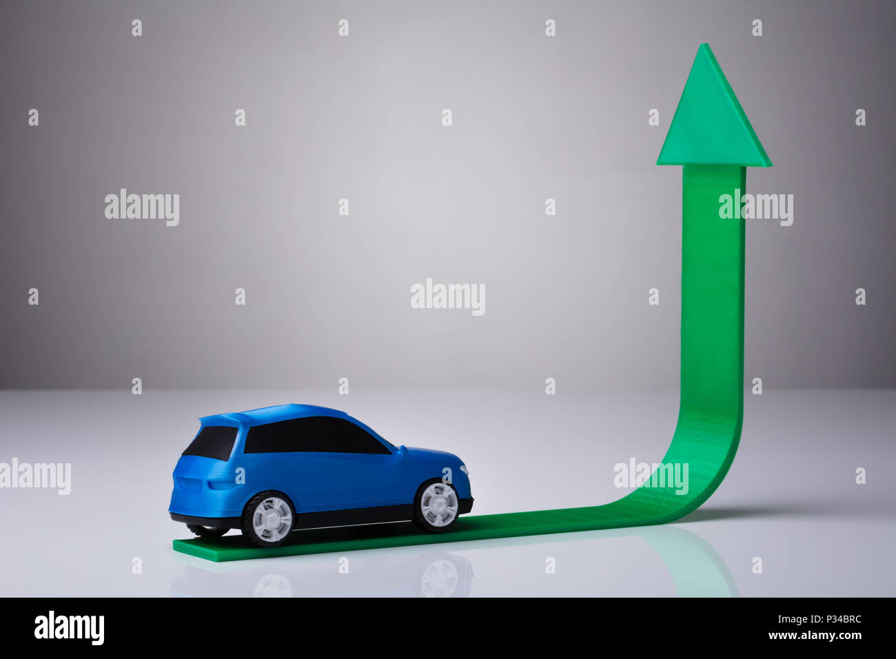 Auto blu guida su Verde freccia verso l'alto contro lo sfondo grigio Foto Stock