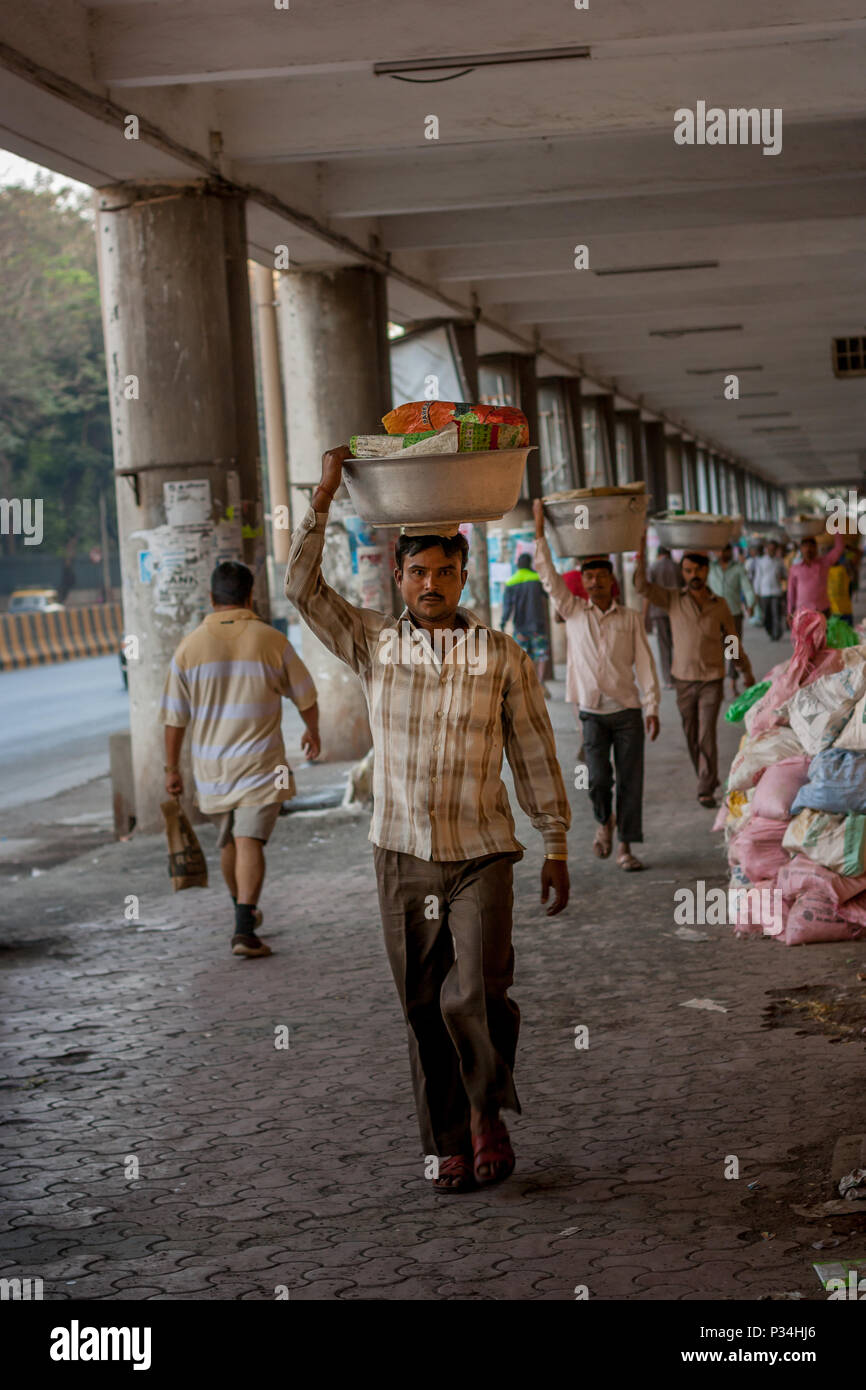 MUMBAI, India - 29 gennaio 2017: l'uomo non identificato carryng peso sulla sua testa - un secchio pieno di pesce fresco Foto Stock