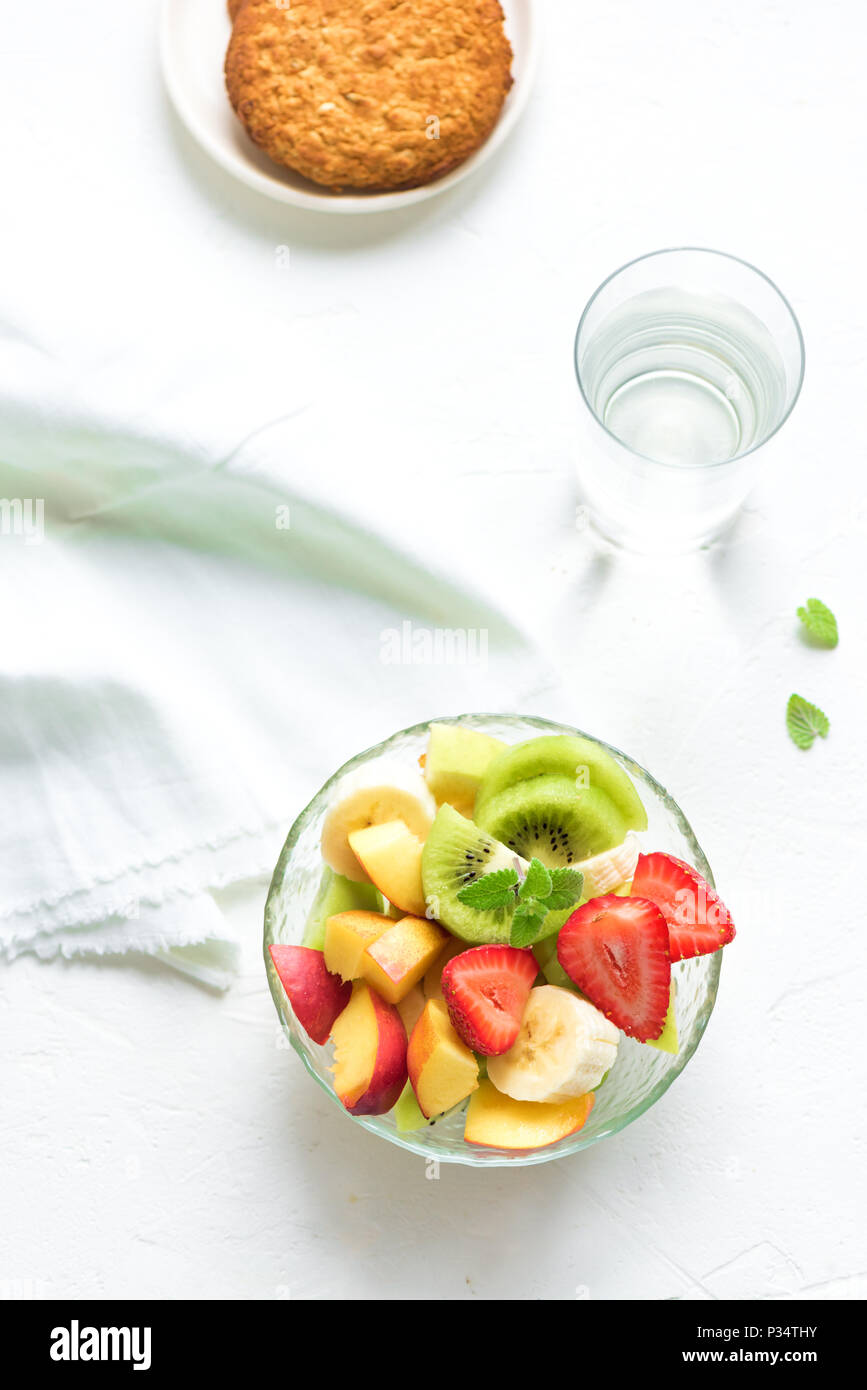 Insalata di frutta in vaso per una sana colazione o uno spuntino. La dieta vegetariano crudo alimentare fitness e il concetto di stile di vita, sfondo bianco con copia spazio. Foto Stock