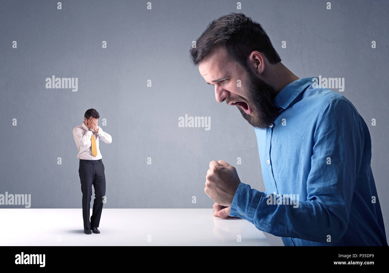 Giovane imprenditore professionale essendo arrabbiato con un altro imprenditore in miniatura Foto Stock
