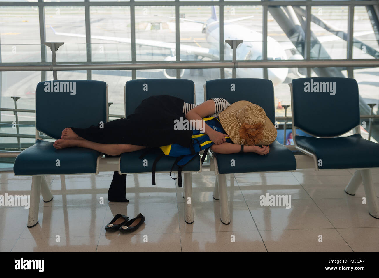 Bangkok, Thailandia, donna addormentata in area di partenza all'aeroporto di Bangkok Foto Stock