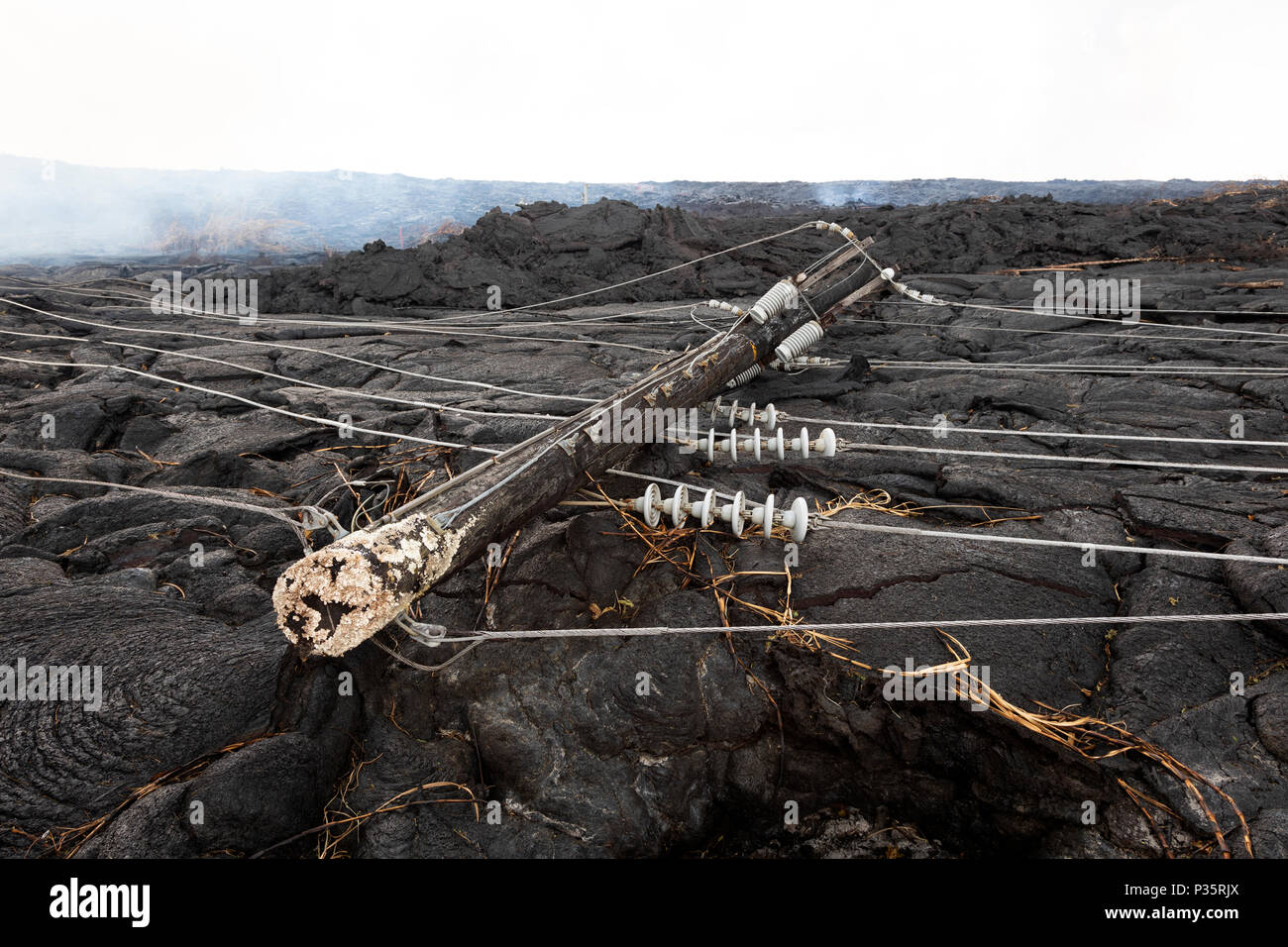 Linea elettrica ad alta tensione distrutta da un flusso di lava in Hawaii Foto Stock
