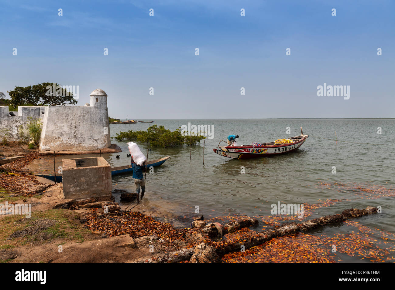 Cacheu, Repubblica di Guinea Bissau - 1 Febbraio 2018: i pescatori preparano le loro canoe nel porto della città di Cacheu in Guinea Bissau. Foto Stock