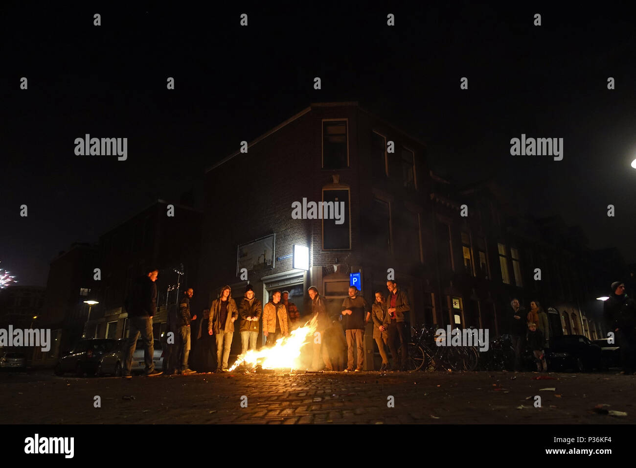 Utrecht, Paesi Bassi, le persone sono in piedi nella strada di fronte a un piccolo incendio di notte Foto Stock
