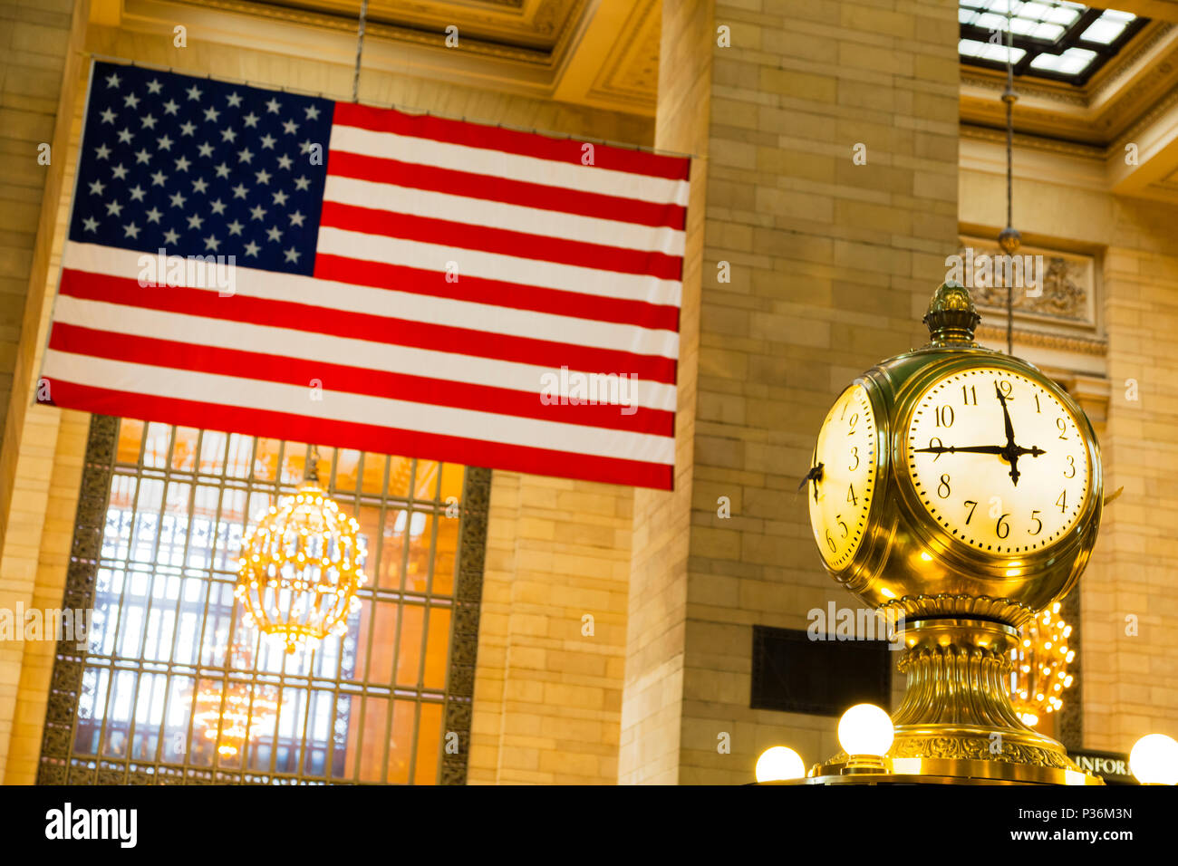 Un vecchio orologio di fronte un Stati Uniti bandiera alla Grand Central Station nel centro di New York City, Stati Uniti d'America. Foto Stock