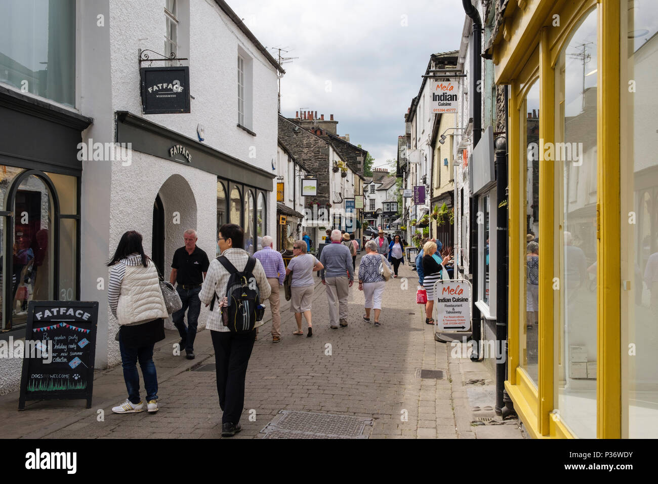 Gli amanti dello shopping e negozi su strada stretta nel vecchio Lago Città distretto. Ash Street, Bowness on Windermere, Cumbria, Regno Unito, Gran Bretagna Foto Stock