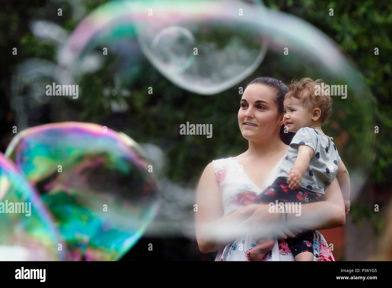 I Bambini a caccia di bolle creata da un esecutore di strada su Boston Common, Boston, Massachusetts Foto Stock