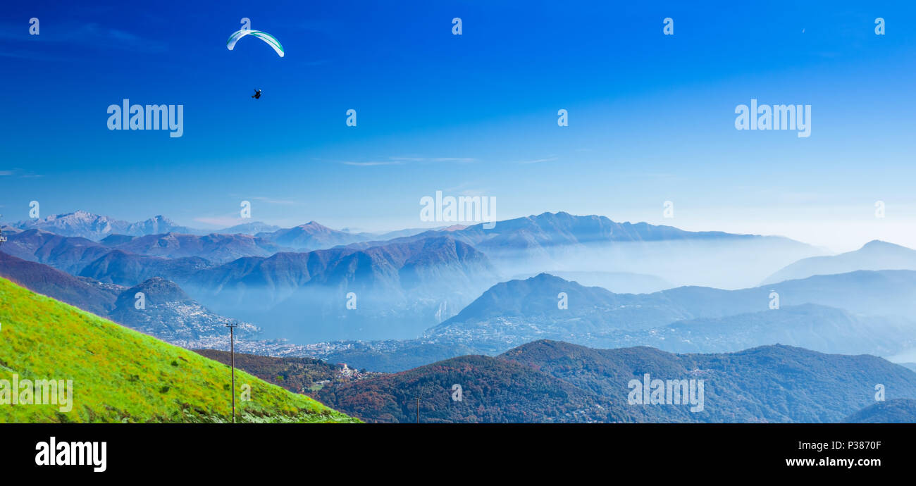 Parapendio sopra la città di Lugano, San Salvatore montagna e lago di Lugano vista dal Monte Lema, Canton Ticino, Svizzera Foto Stock
