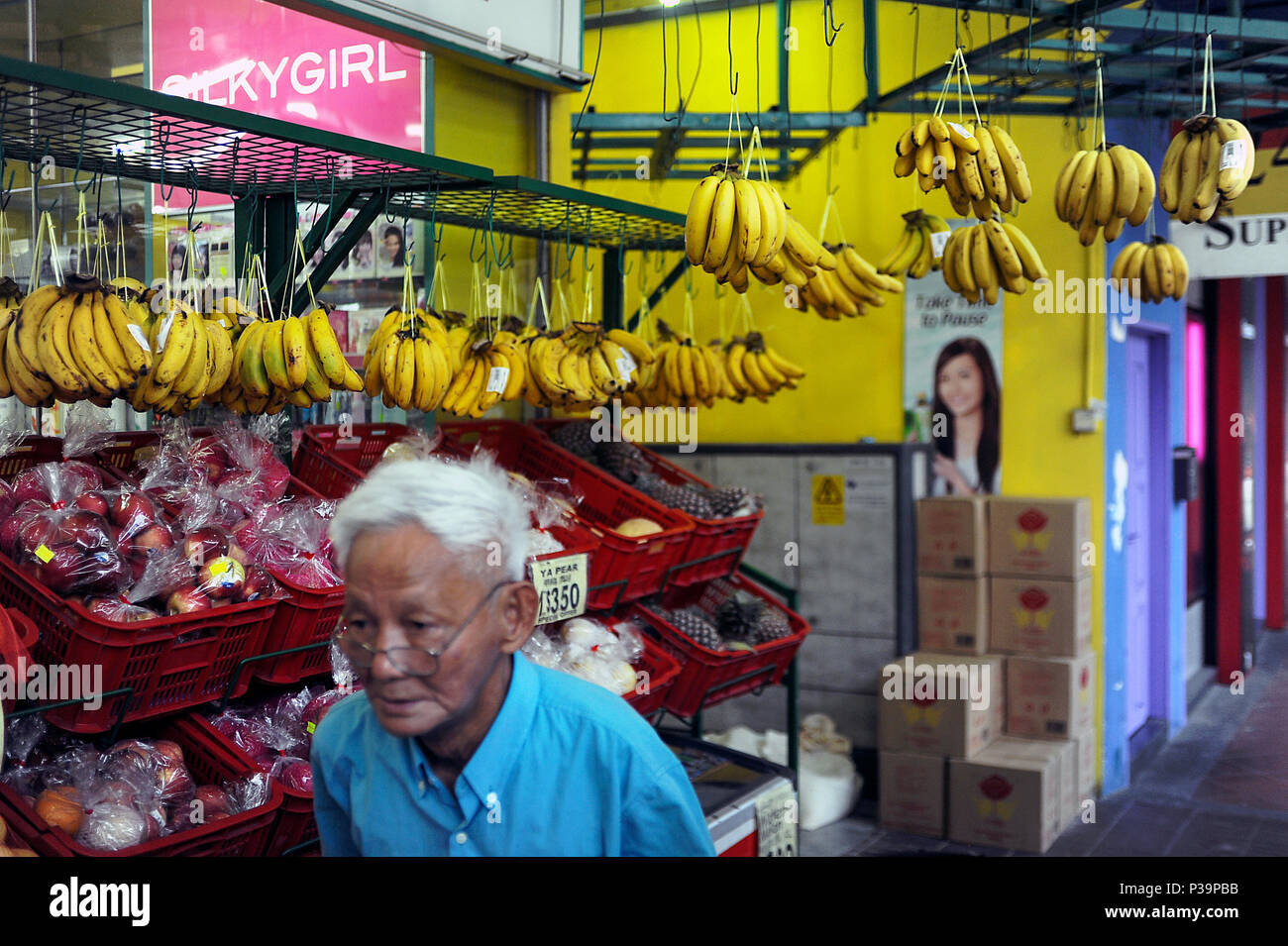 Singapore Repubblica di Singapore, banane appeso davanti a un negozio di alimentari Foto Stock