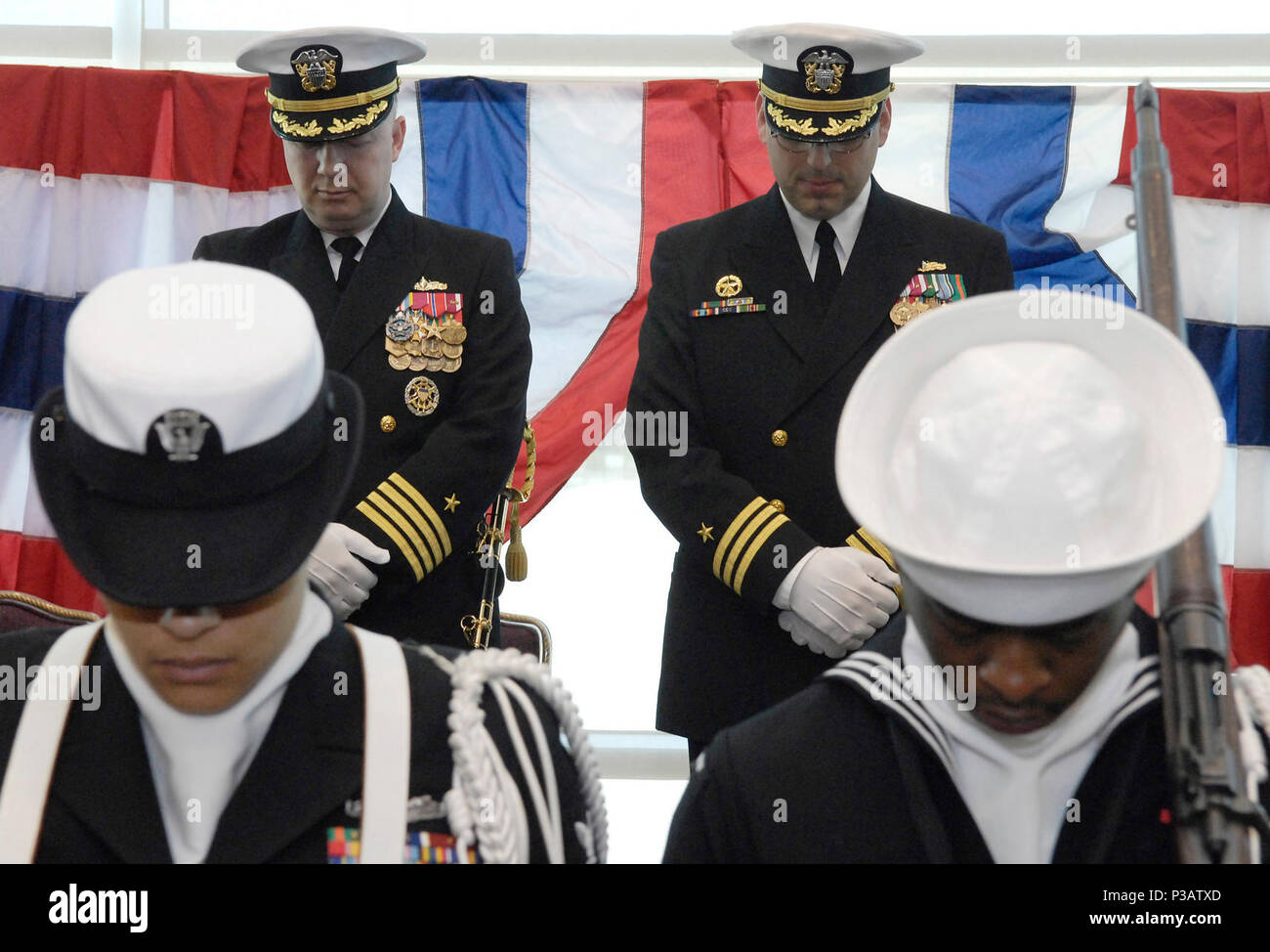 Stazione Everett (GEN. 12, 2006) - Capt. Jeffrey Harley, Comandante Destroyer Squadron nove (DESRON 9), a sinistra e a quella della Cmdr. Jonathan cristiano, Commodore a galla gruppo Formazione Pacific Northwest, diritto, prua le loro teste durante l invocazione all'inizio della modifica del comando cerimonia di premiazione che si terrà a galla per gruppo di addestramento Pacific Northwest in Grand Sala da Ballo di Vista alla stazione navale di Everett. Stati Uniti Navy Foto Stock