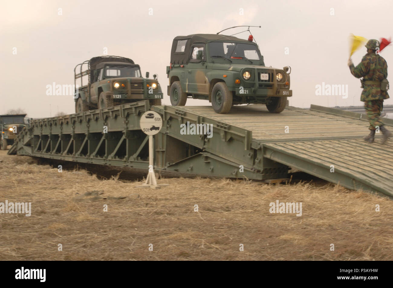 Una repubblica di Corea soldato assegnato al settantacinquesimo Bridge Seoul Construction Company segnali per due veicoli per passare al di sopra di una nuova costruzione Trave medio bridge durante l'esercizio risolvere/puledro Eagle 2008 a Seoul, Corea del Sud, 6 marzo 2008. Annuali congiunte command post e formazione sul campo esercizio dimostra risolvere negli Stati Uniti per sostenere la Corea del Sud contro le aggressioni esterne migliorando al tempo stesso la Combat Readiness e giunto/combinato di interoperabilità. Foto Stock