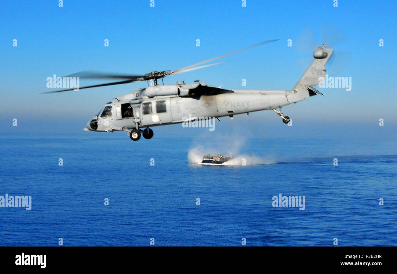 OCEAN (dec. n. 6, 2008) un MH-60S Knighthawk elicottero sorvola un Landing Craft Air Cushion dal trasporto anfibio dock nave USS New Orleans (LPD 18). New Orleans è su un esercizio di certificazione come parte del Boxer Expeditionary Strike gruppo in preparazione per una prossima distribuzione. Foto Stock