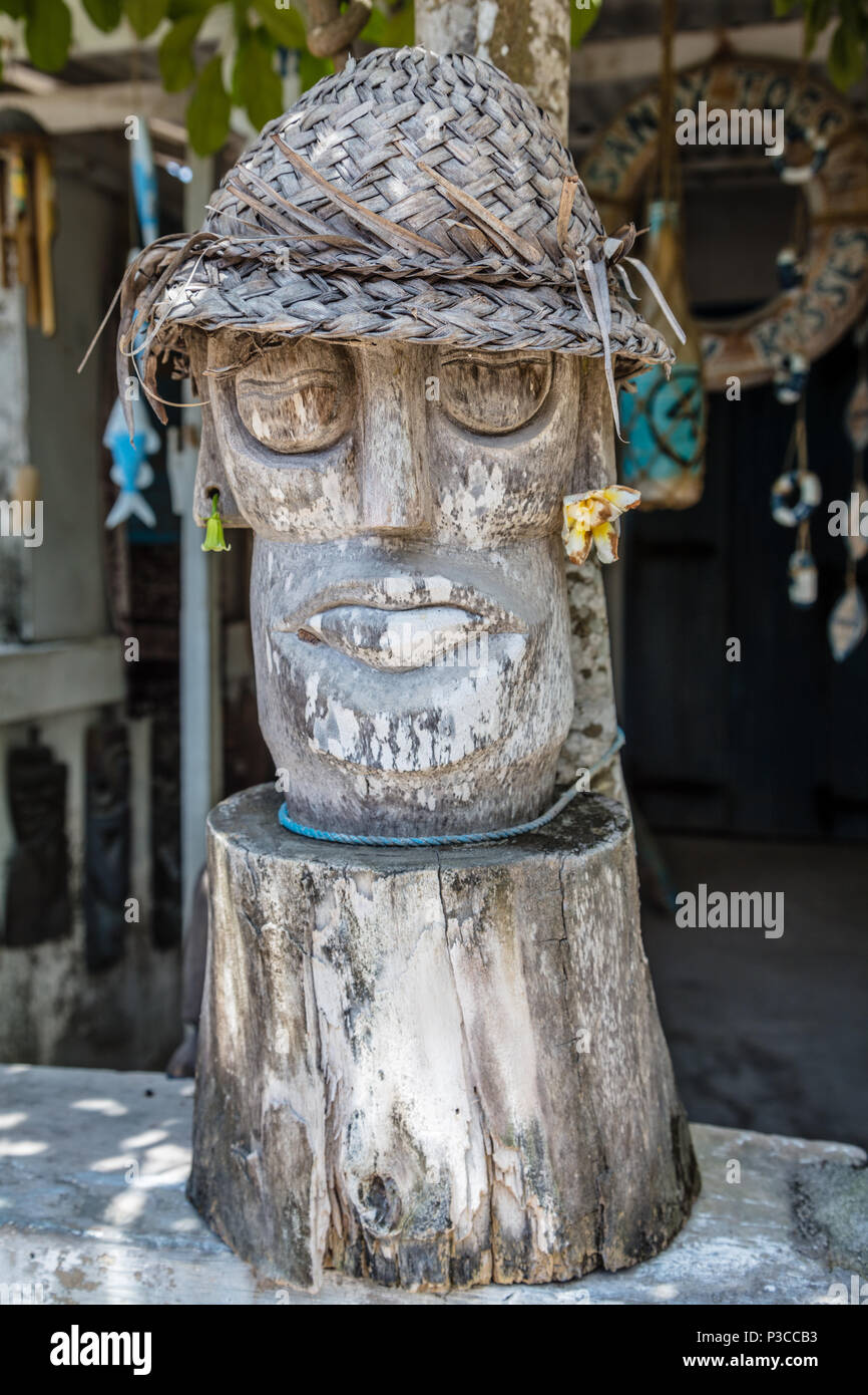 Scolpito statua in legno in stile Balinese tradizionale cappello di paglia vicino ad una casa locale Nusa Lembongan, Indonesia Foto Stock