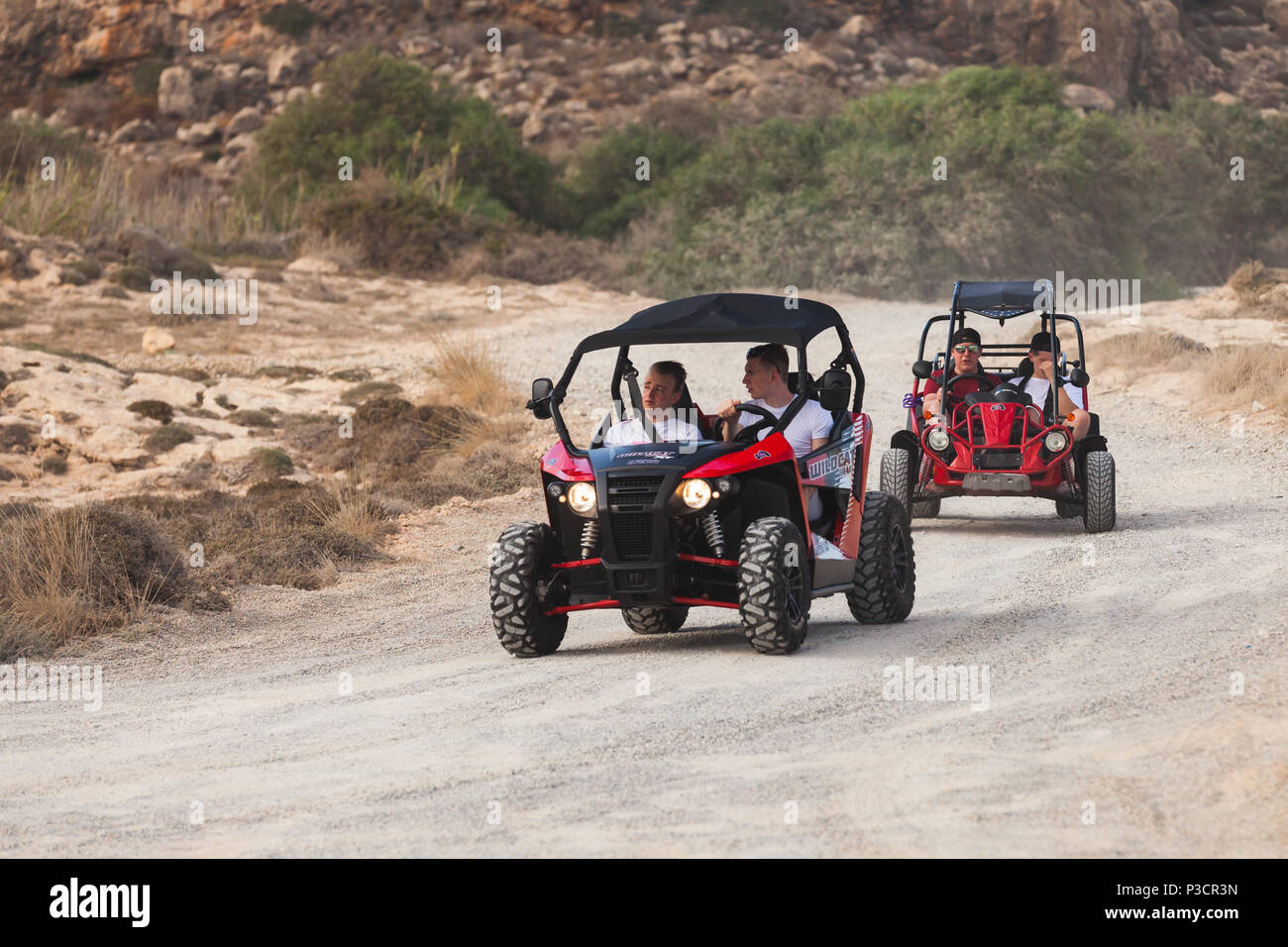 Ayia Napa, Cipro - 11 Giugno 2018: due red affittati ATV con giovani automobilisti europei sono sporchi su strada rurale di isola di Cipro Foto Stock