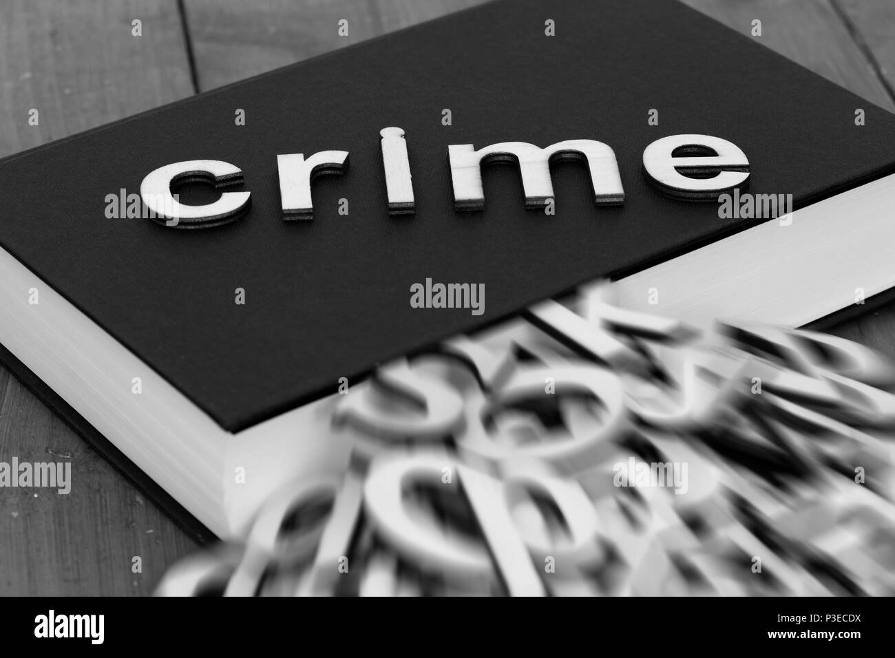 Prenota romanzo con la parola la criminalità e sfocata lettere in uscita delle pagine su uno sfondo di legno Foto Stock