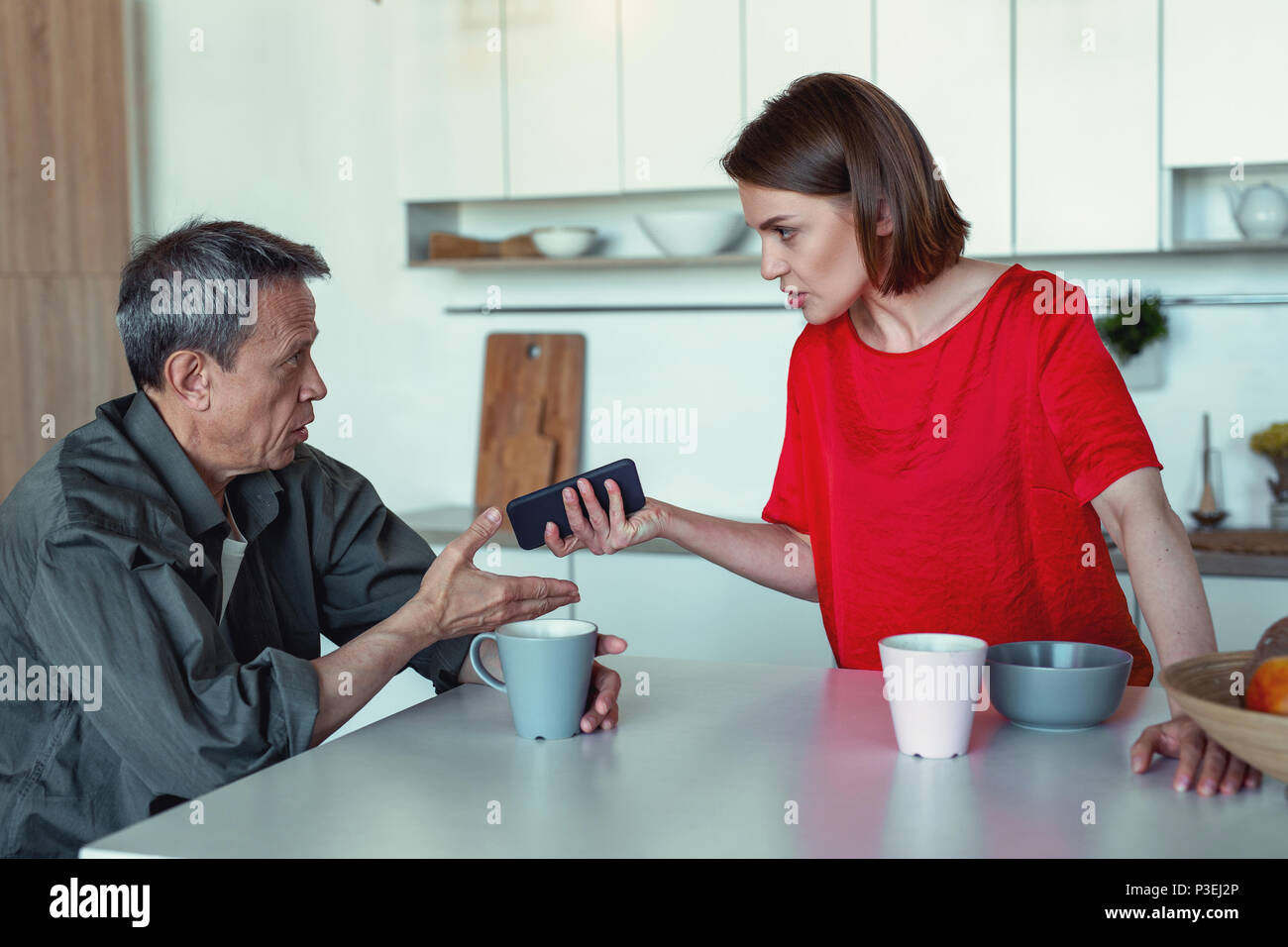 Emotional giovane sostenendo circa il finanziamento durante l ora del tè Foto Stock