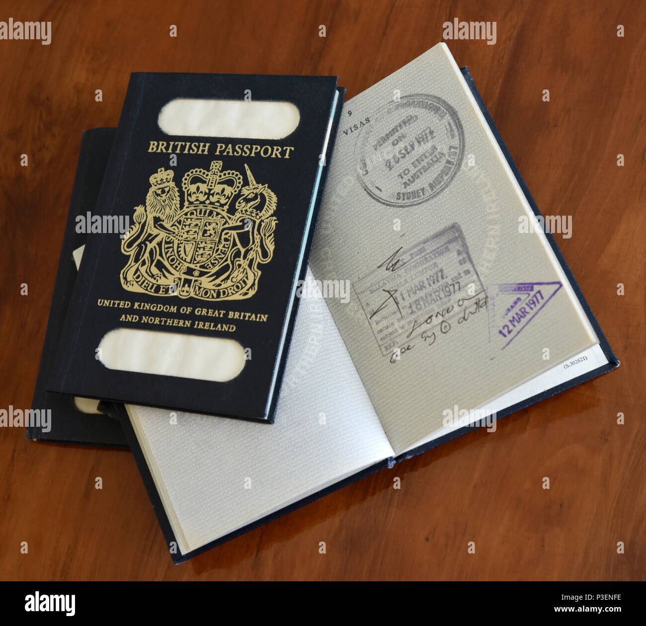Blu passaporti britannici con una aperta con entrata e uscita timbri illustrato sulla antica scrivania Foto Stock